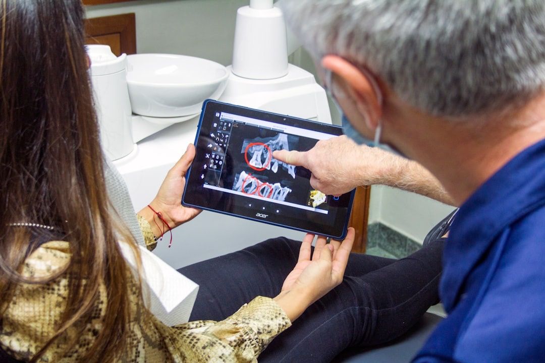 A dentist reviewing digital dental images with a patient
