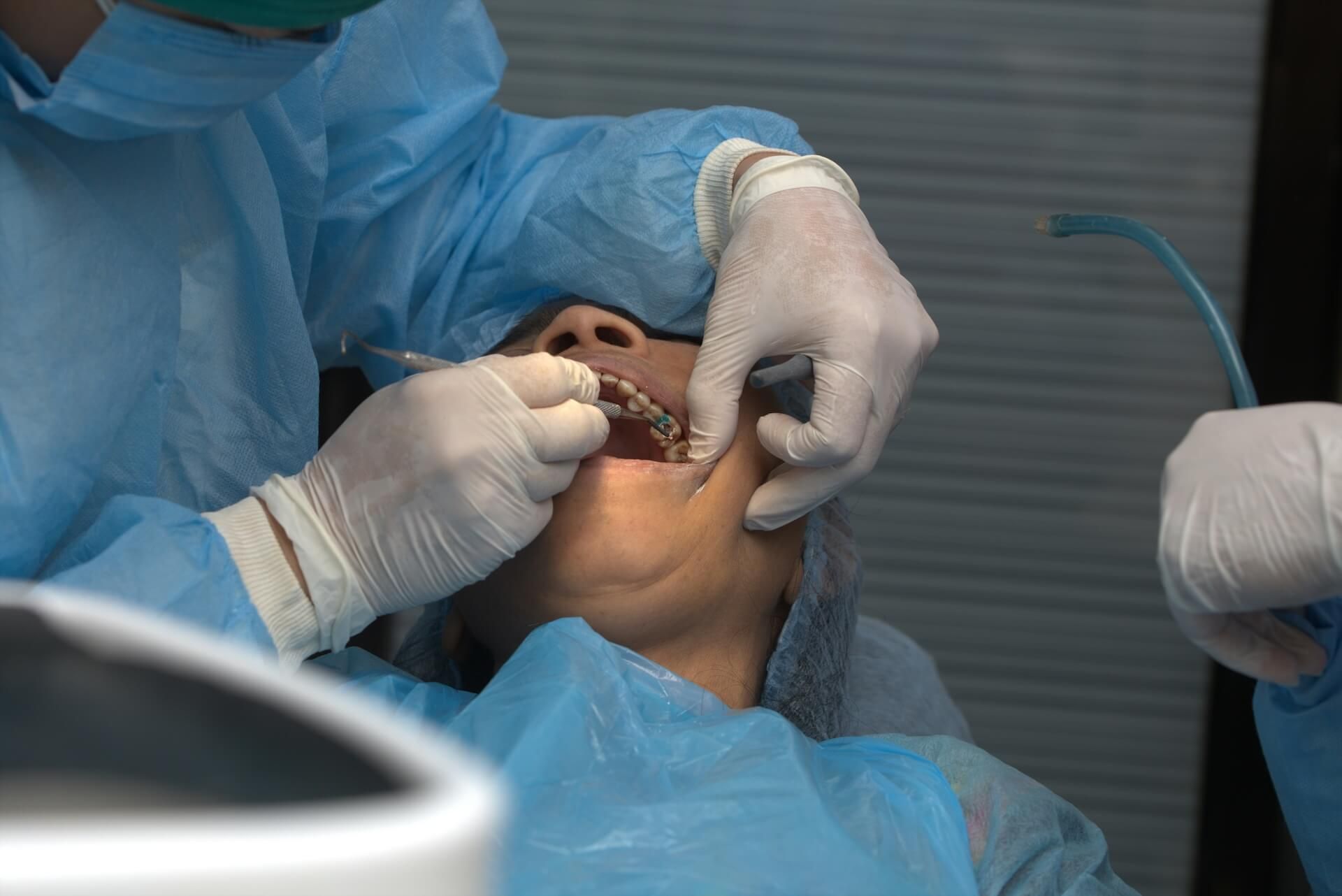 A dental professional preparing a patient for an extraction-site preservation procedure