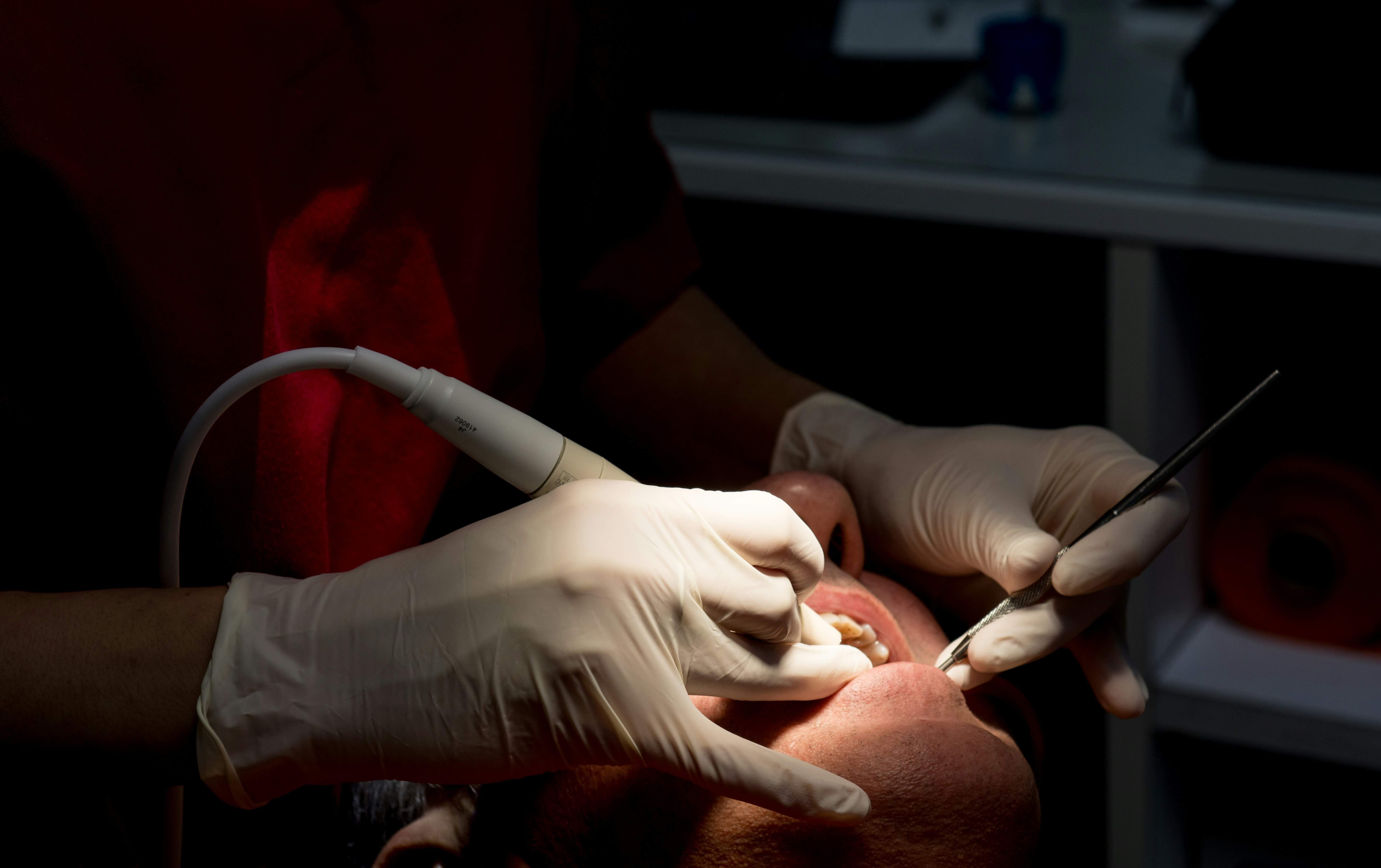 A dental professional providing periodontal care to a patient
