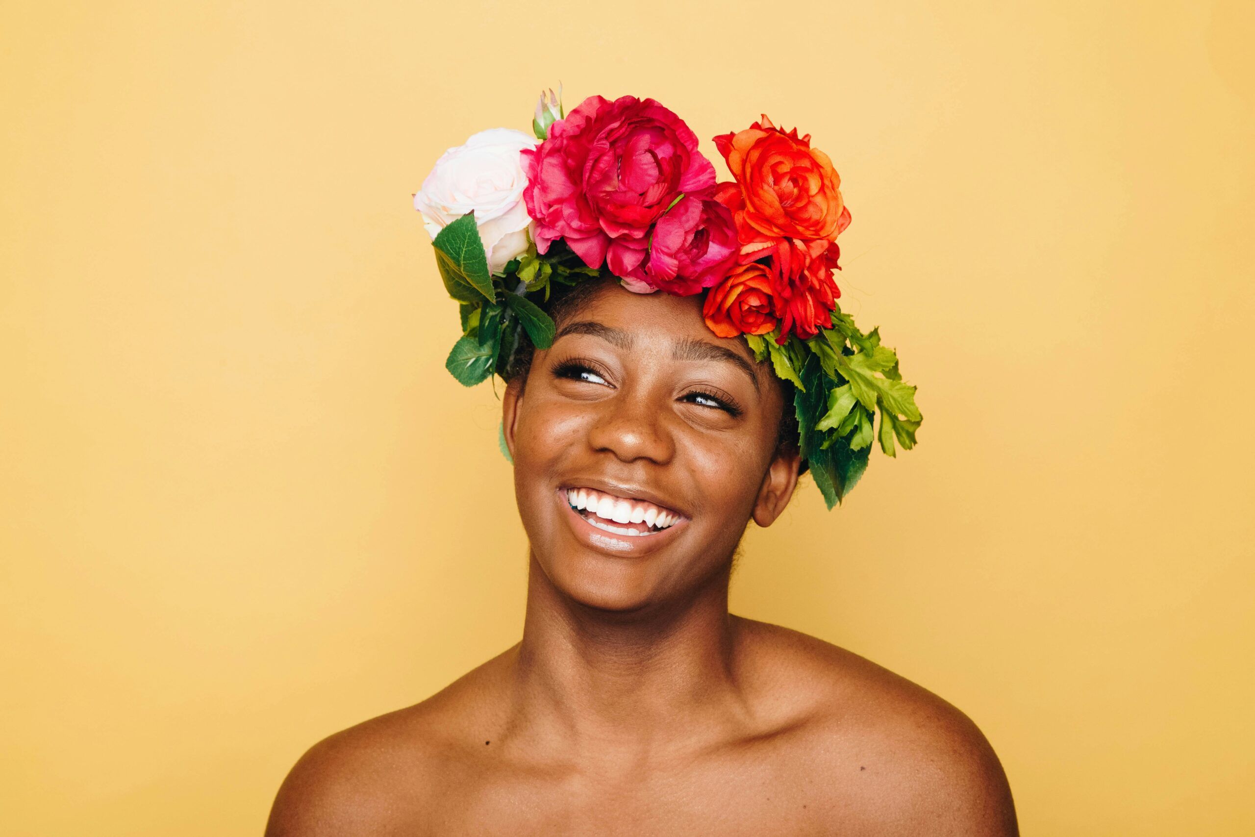 A smiling person wearing a colorful flower crown